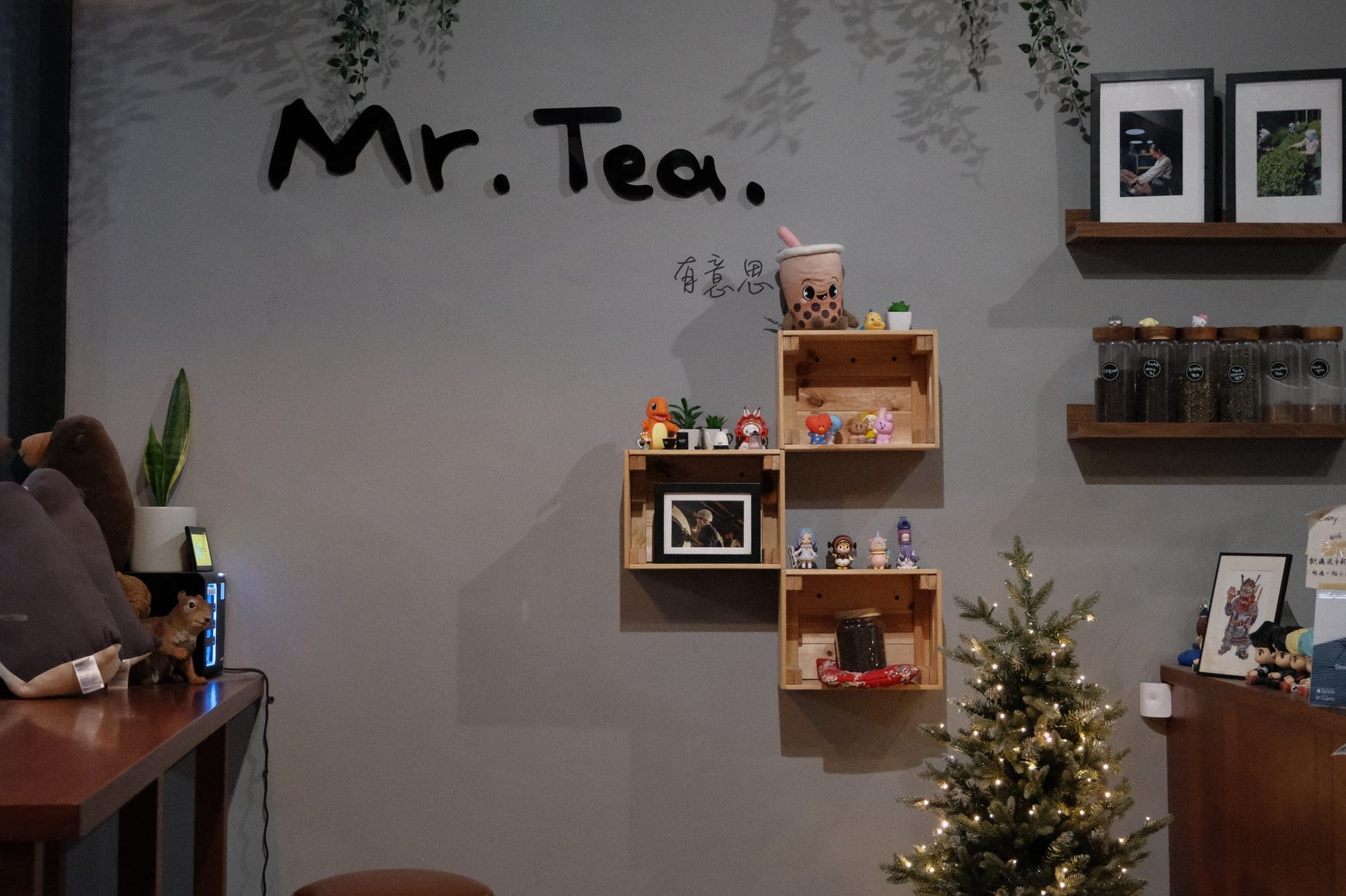The hand-painted “Mr. Tea.” sign inside the shop, above wooden crate shelves of little figurines